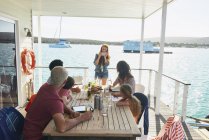 Сім'я зібралася в таблиці на houseboat Тераса для засмаги, Kraalbaai, Південно-Африканська Республіка — стокове фото