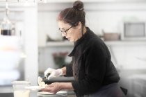 Mulher trabalhando na cozinha do restaurante, servindo refeição — Fotografia de Stock
