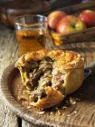 Pork, bacon and leek pie with glass of cider — Stock Photo