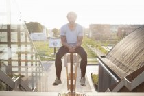 Porträt eines Mannes, der nach dem Training auf einem Geländer sitzt — Stockfoto