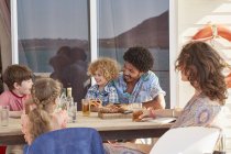 Family gathered at table on houseboat sun deck, Kraalbaai, South Africa — Stock Photo