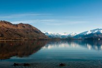 Montañas y cielo reflejados en el lago - foto de stock