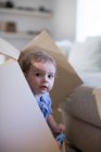 Baby boy in cardboard box peeking out — Stock Photo