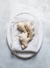 Ginger root on linen cloth on white background — Stock Photo