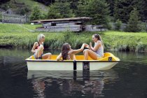 Drei erwachsene freundinnen beim ruderboot am see, sattelbergalm, tirol, österreich — Stockfoto