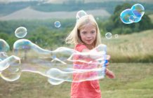 Girl playing with soap bubbles — Stock Photo