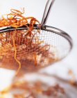 Deep fried carrot slices in sieve, close up shot — Stock Photo