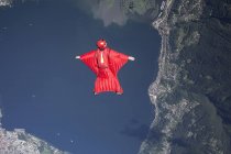 Wingsuit skydiver pilot flying over lake, Locarno, Tessin, Switzerland — Stock Photo