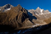 Заснеженные скалистые горы и долина в ярком солнечном свете — стоковое фото