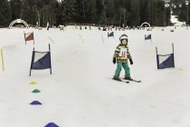 Молодая девушка катается на лыжах через флаги — стоковое фото