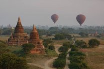 Globos de aire caliente y templos antiguos al atardecer, Bagan, Birmania - foto de stock