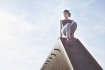 Женщина тренируется, спускается по городскому мосту — стоковое фото