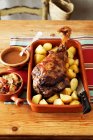 Baked lamb leg with roast potatoes and vegetables — Stock Photo