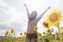 Середня доросла жінка в галузі соняшників — стокове фото
