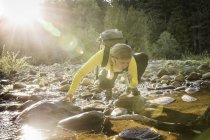 Escursionista che beve acqua di fiume utilizzando il filtro dell'acqua nel Englishman River Falls Provincial Park, Vancouver Island, British Columbia, Canada — Foto stock
