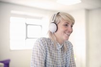 Молода жінка слухає навушники — стокове фото