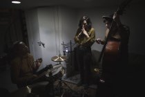 Музыканты с двойным басом и барабанами в музыкальной студии — стоковое фото