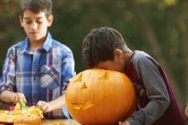 Siblings hollowing out pumpkin at home — Stock Photo