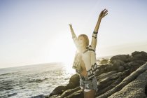 Mid adult woman on sunlit beach with arms raised, Cape Town, South Africa — Stock Photo