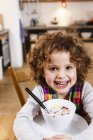 Ritratto di ragazza con ghigno dentato con cereali in cucina — Foto stock
