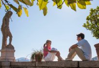 Coppia seduta sulla parete del giardino mediterraneo, Lago Maggiore, Italia — Foto stock