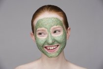 Junge Frau mit Gesichtsmaske, lächelnd — Stockfoto