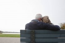 Coppia anziana seduta sulla panchina nel parco — Foto stock