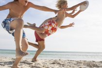 Junge und Vater rennen zu Bruder mit Rugby-Ball am Strand, Mallorca, Spanien — Stockfoto