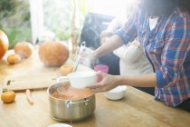 Mother serving pumpkin soup for daughter in kitchen — Stock Photo