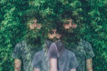 Потрійний експозиційний портрет прозорого молодого чоловіка і зелене листя — стокове фото