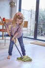 Girl mopping dining room floor — Stock Photo