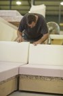 Male upholsterer checking furniture box frame — Stock Photo