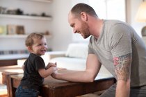Smiling baby boy and father arm wrestling — Stock Photo