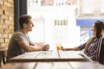 Side view of young couple chatting in bar — Stock Photo