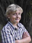 Портрет улыбающегося мальчика со сложенными руками — стоковое фото