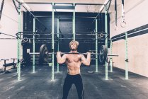 Young male cross trainer weightlifting barbell in gym — Stock Photo