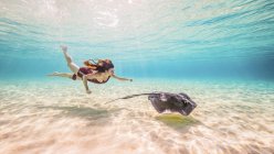Freitaucherin schwimmt mit Rochen auf Meeresgrund — Stockfoto