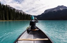 Молодая женщина каноэ, вид сзади, Изумрудное озеро, Национальный парк Йохо, Канада — стоковое фото