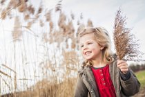 Young girl collecting marsh grasses — Stock Photo