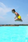Rapaz saltando para a piscina — Fotografia de Stock