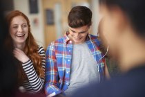 Young male and female students laughing in common room — Stock Photo
