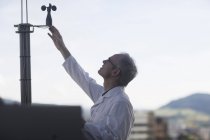 Männlicher Meteorologe überwacht meteorologische Ausrüstung an der Wetterstation auf dem Dach — Stockfoto