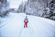 Boy looking up from snow covered highway, Hemavan, Suécia — Fotografia de Stock