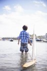 Porträt eines Jungen, der mit einem Modellboot spielt — Stockfoto