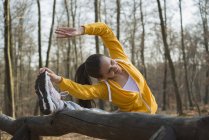 Junge Frau streift Zehen auf Angriffskurs im Wald — Stockfoto