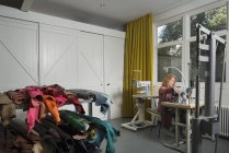Mujer en la máquina de coser en el taller - foto de stock
