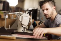 Mann näht mit Nähmaschine Leder in Lederjacken — Stockfoto