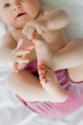 Baby girl playing with feet — Stock Photo
