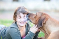 Ritratto di cane leccare il viso della ragazza — Foto stock