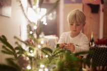 Niño joven decorando árbol de Navidad - foto de stock